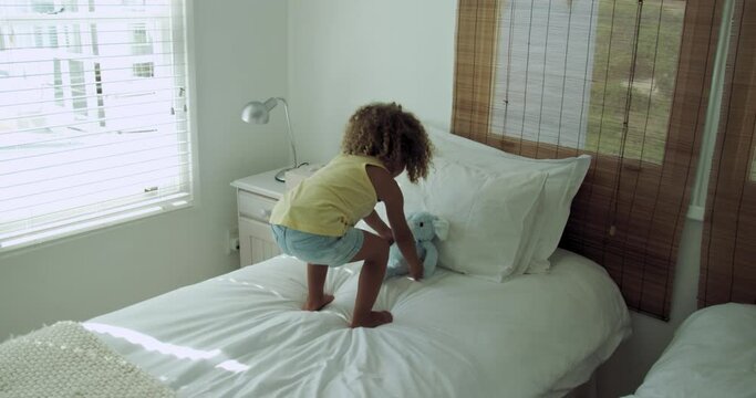 SLO MO WS Little girl (4-5) playing on bed / Claremont, Cape Town, South Africa