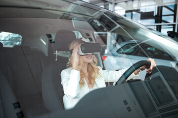 Pretty woman sitting in a car in 3D glasses of virtual reality