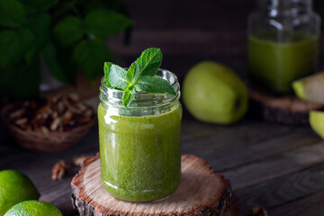 Fresh green smoothie on rustic wooden background