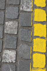 Gray cobblestone background with bright yellow line