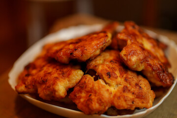 Homemade chicken cutlets. The plate is full of delicious chicken meatballs prepared for food. Fried chicken cutlets. Grilled chicken breast on a white dish on an old wooden background.