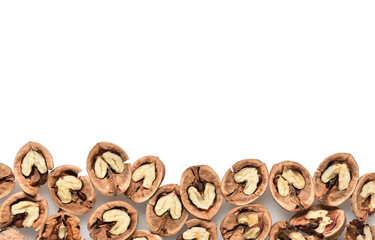 Cracked and open walnuts on a white background with copy space. Chopped nuts