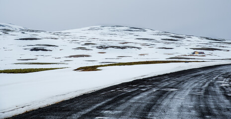 Empty countryside frozen road and Icelandic meadow with snow in winter in Iceland