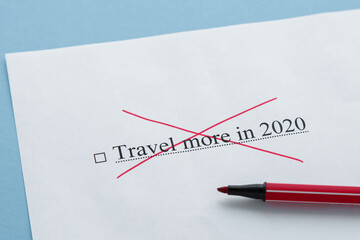 piece of paper with the inscription travel more in 2020 from to do list crossed out with a red marker, tourism crisis 