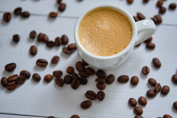 Espresso coffee on a white wooden table with coffee beans.