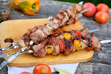 Freshly cooked barbecue on a wooden table. Summer lunch in nature. Tasty meat dish cooked on the fire.