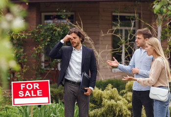 Troubled real estate broker dealing with disturbed clients about buying new house, outdoors