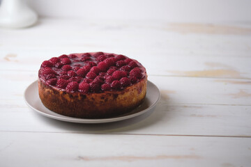 Preparing a morning breakfast with raspberry cheesecake. Dessert on a white wooden table.