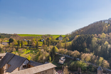 Obraz premium Village of Vianden with road between green fields view from castle, Luxembourg