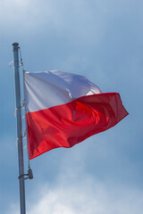 Biało czerwona polska flaga łopocze na tle nieba, patriotyzm, 11 listopad