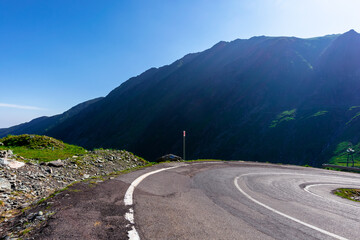 mountain road on a sunny morning. empty highway uphill through valley.  great european journey in...