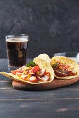 Mexican tacos on an old wooden table. Fast food and cola for lunch.