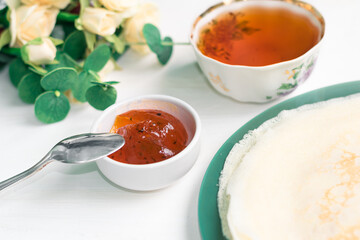 Pancakes, a bouquet with roses, a beautiful vintage breakfast. Sea buckthorn jam. Romantic breakfast for Valentine's Day on February 14 on a white background. Greeting card template. Mother's day card