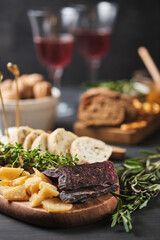 Delicious snacks and wine. Several varieties of cheese, nuts, ciabatta and sausage on an old wooden table. Food for a romantic dinner.