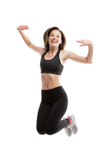 Laughing young girl in sportswear is jumping. Sport and movement. Isolated on a white background. Vertical.
