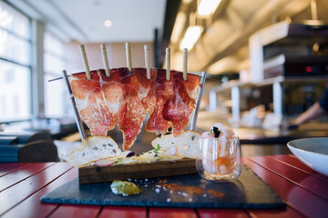 jerky meat hangs on a stand and fastened with clothespins. garnished with thin dried slices of...