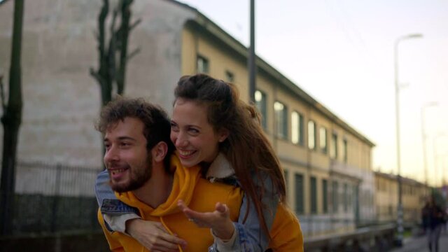 MS TS Man giving friend piggyback ride / Milan, Italy