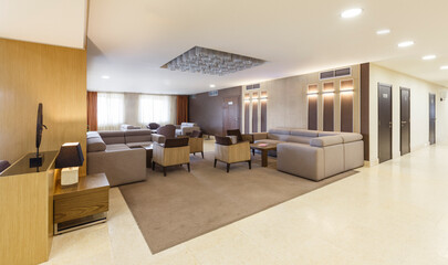 Lounge area with large gray sofas and armchairs in hotel