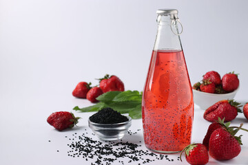 Healthy drink strawberries with basil seeds in a bottle on white background, Closeup, Copy space