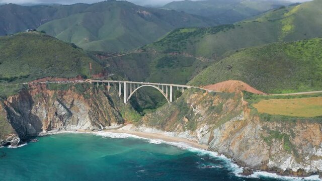 Bixby Creek BridgeBreathtaking aerial footage of the mountain landscape and rocky coast washed by vibrant blue water of Pacific ocean. 4K