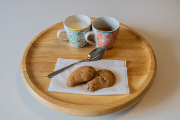 Breakfast Wooden Plate with Milk and Coffee Original Cups Two Chocolate Cookies and Silver Spoon