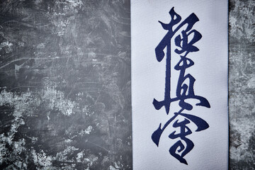 Calligraphy - Kyokushinkai karate symbol on rustic wooden background. Top view. Copy space. 