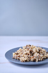 Risotto with mushrooms close-up on a gray plate. Italian dish on a white wooden table.