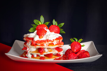 Stack of fresh pancakes with strawberries and whipped cream