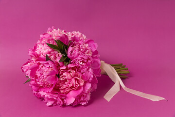 bouquet of pink peonies on a pink background