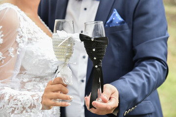 The groom and the bride are holding glasses.