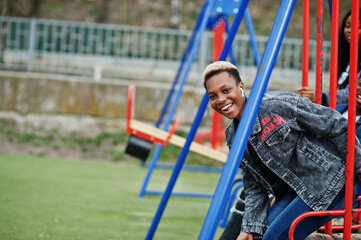 Obraz premium Young millennials african friends on playground, slide and swing. Happy black people having fun together. Generation Z friendship concept.