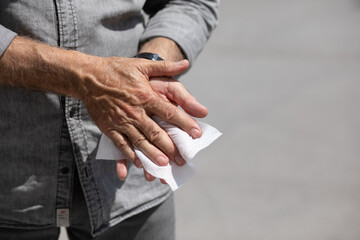 Man cleaning hands with wet wipes