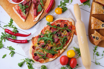 Homemade Italian pizzas: spicy with chili and smoked sausage; piquant with olives and two kinds of sausages; calzone with mazarella, tomatoes, tomato sauce, sausage, olives and arugula.