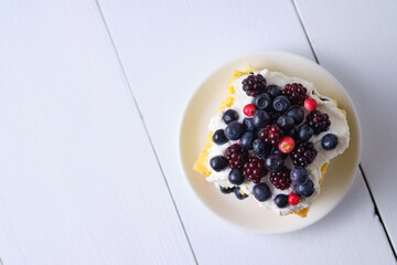 Summer biscuit cake with fresh blueberries and blackberries with curd cream. Top view.