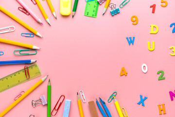Many different school supplies on pink background. Back to school concept.