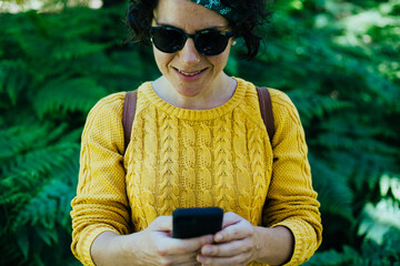 mujer en el monte con telefono y auriculares