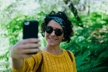 mujer en el monte con telefono y auriculares