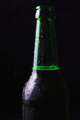 Misted cold bottle of beer on a black background.