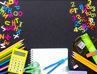 Many different school supplies on blackboard copy space background. Back to school concept.