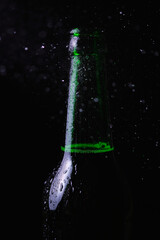 Water splashes crash into a fogged cold bottle of beer on a black background.
