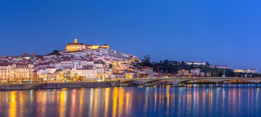 Fototapeta premium historic Coimbra cityscape with university at top of the hill in the evening, Portugal