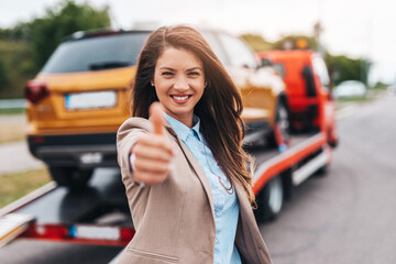 Elegant middle age business woman is happy and satisfied with fast and reliable towing service for...
