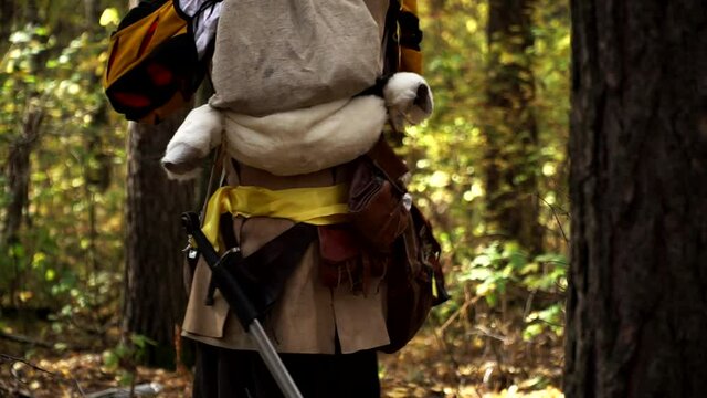 Larp player dressed in costume is making few steps in autumn forest. The actor is wearing personage clothes and playing the role. Theme of live acting role plays and its' actors.