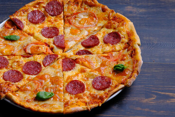 Pepperoni pizza and margarita pizza together. Joint pizza on a dark wooden background. Homemade pizza.