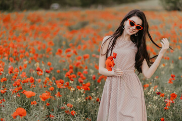 Girl posing in poppy field with red glasses