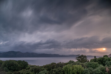 Menacing clouds and a timid sun over the Mediterranean island of Corsica