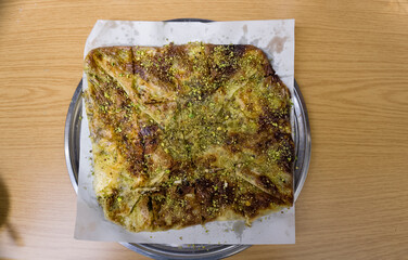 Delicious Turkish dessert as known Katmer on wooden table. The famous and traditional dessert of Gaziantep City of Turkey.