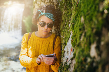 mujer en el monte con telefono y auriculares