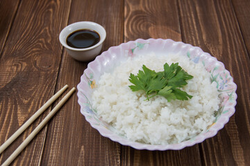 boiled rice with soy sauce close-up on a light background