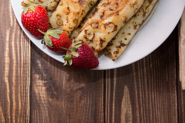fried pancakes and strawberries closeup on a wooden table. Dessert. Healthy breakfast. Proper nutrition